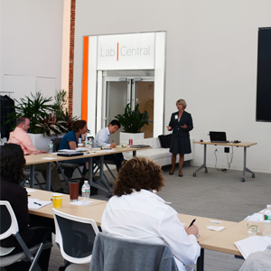 Training attendees take notes in training room with instructor