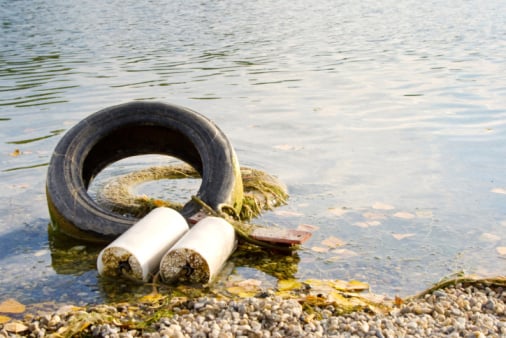 Old tire and discarded items in water