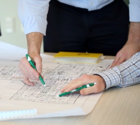 Blueprint of facility with group of people looking over it