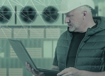 A 3PL worker is on his laptop managing compliance-related tasks.