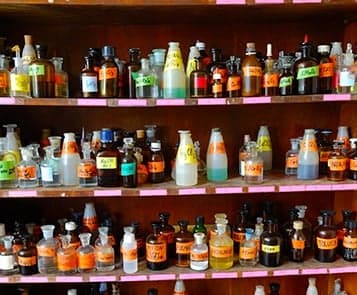 Chemical bottles with labels on shelves