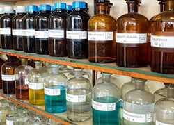 Chemical bottles on lab shelf