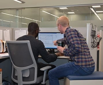 Coworkers collaborating in cubicle