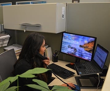 Triumvirate customer support employee at desk
