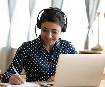 Women wearing headphones at laptop