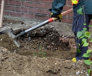 Soil remediation worker shovels soil