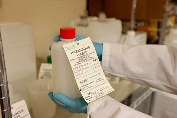 Hazardous waste expert holds chemical bottle