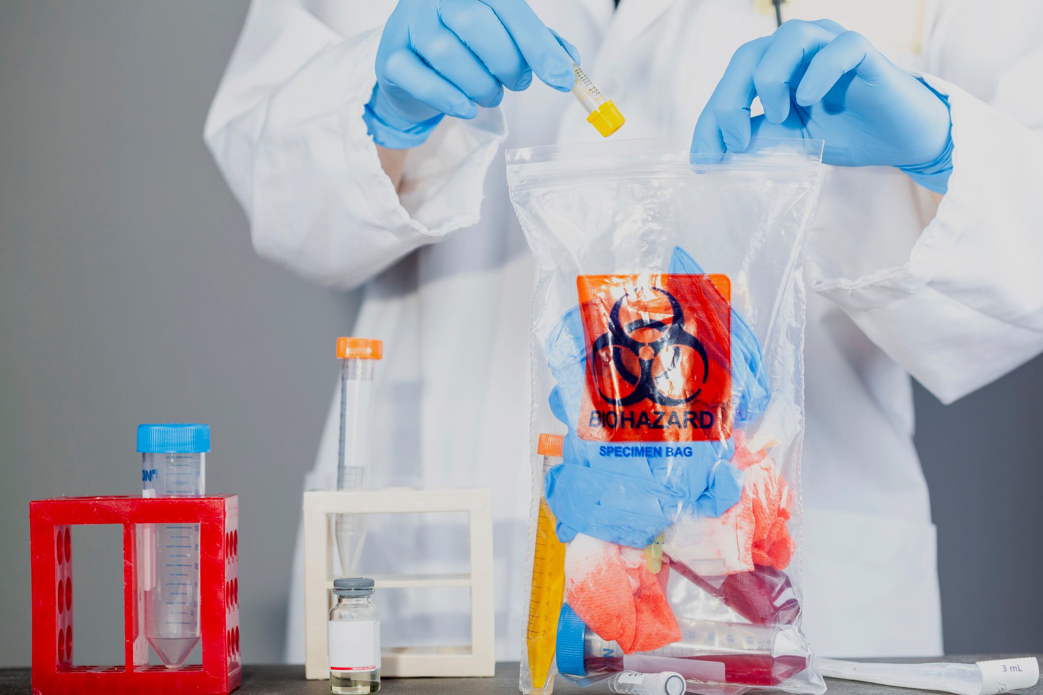 Lab worker fills a biohazard waste bag