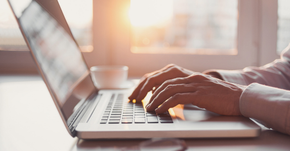 Hands typing on laptop corporate sustainability score