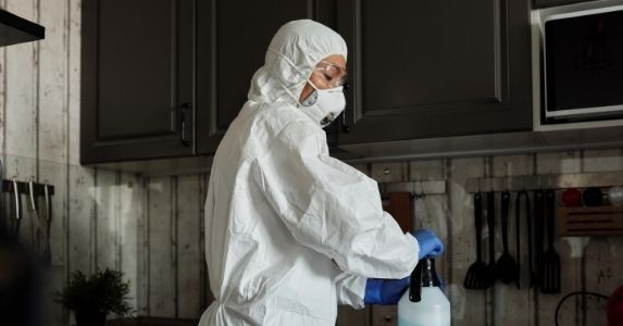 worker wearing full ppe closing bottle