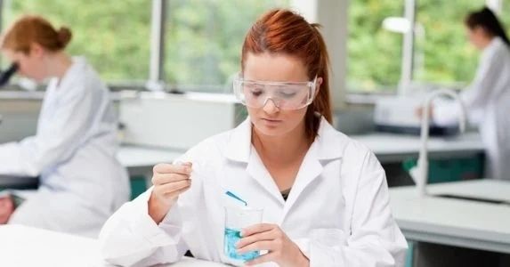 scientist with safety glasses testing chemicals