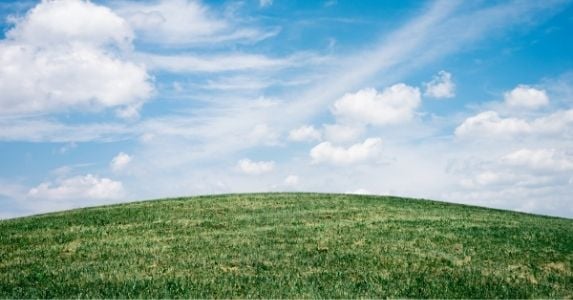 grassy hill and blue sky