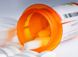 Pharmaceutical orange bottle spilled white capsules