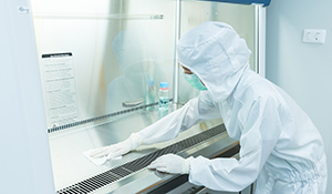 A scientist disinfects a lab as part of a laboratory cleaning, sanitization, and disinfection plan. 