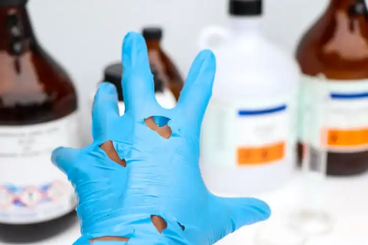 ripped glove reaching for chemicals lab safety