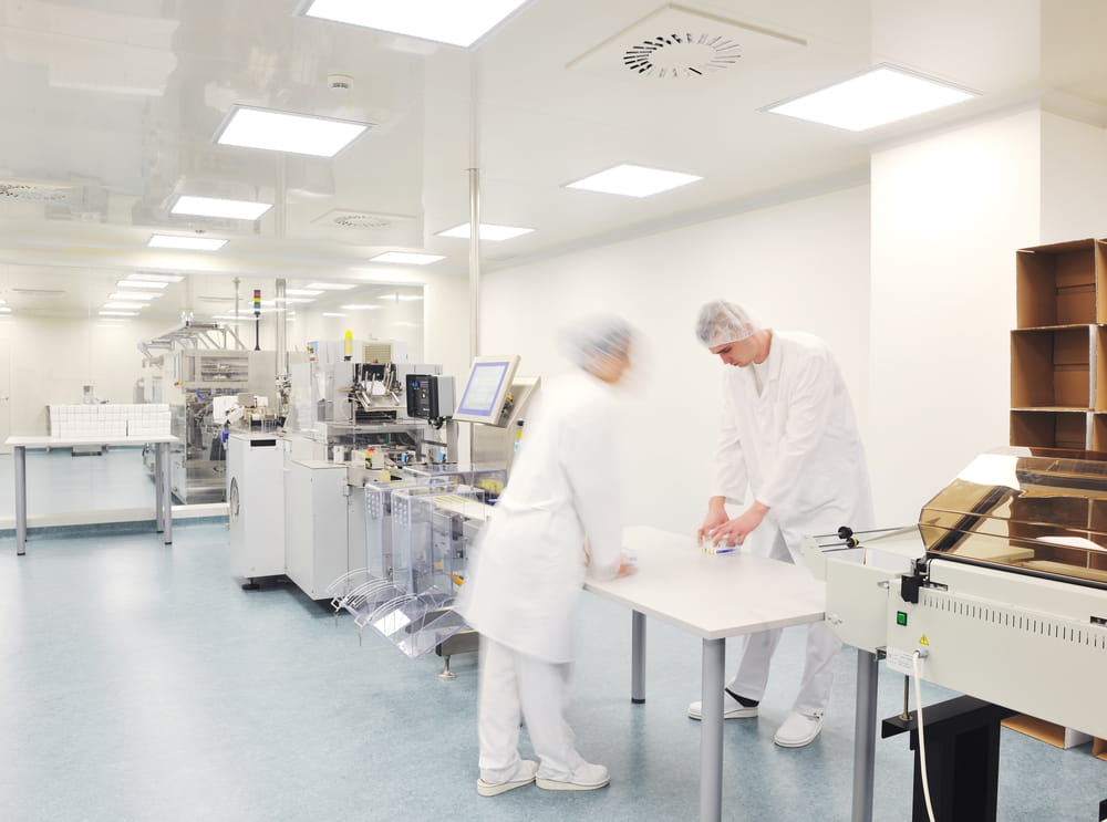 Two lab workers meet at table in laboratory 